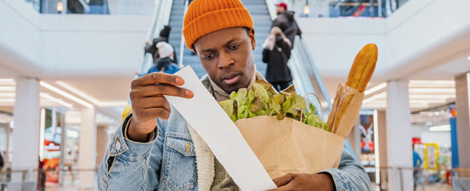 man checking grocery bill in mall